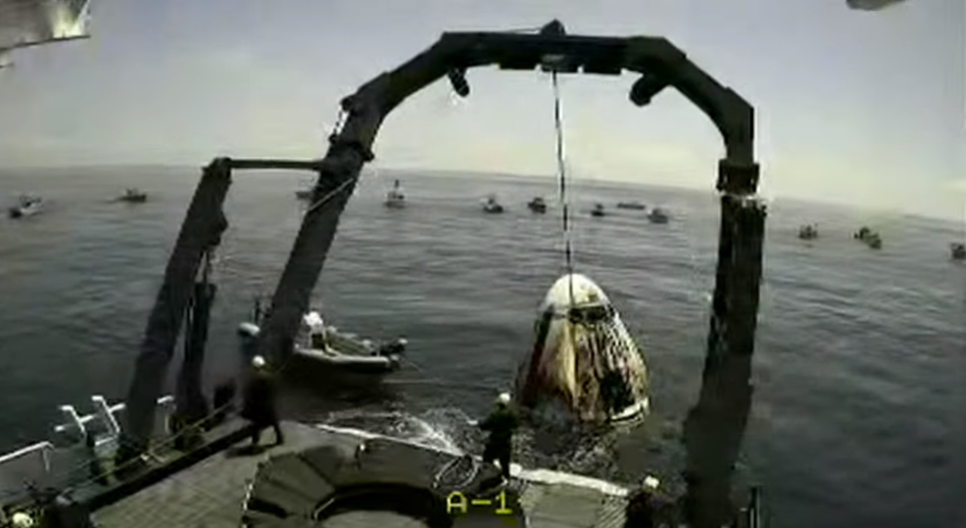 ▲  바다 위에 착륙한 우주선 캡슐을 구조선이 인양하고 있다 / 스페이스X 유튜브 라이브 갈무리