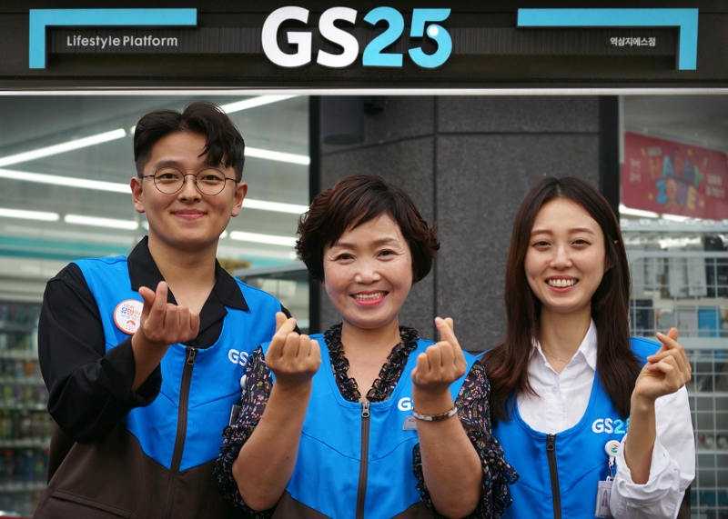 ▲ GS25 직원들과 경영주가 함께 미소지으며 하트를 그려보이고 있다.(사진=GS리테일.)