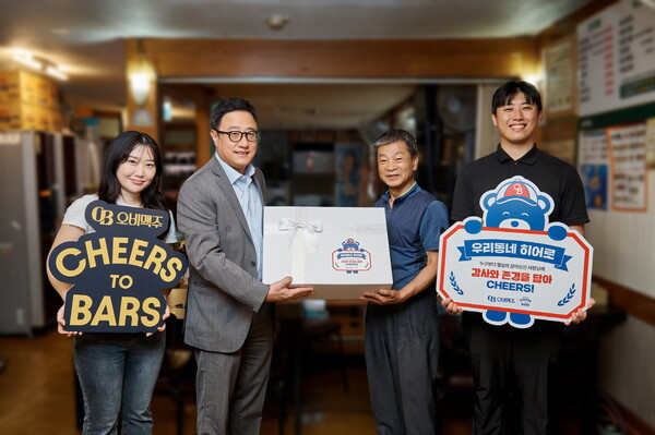 오비맥주 ‘우리동네 히어로’ 캠페인에서 선정된 사연의 업장 사장님이 임직원들과 함께 포즈를 취하고 있다. /사진 제공=오비맥주