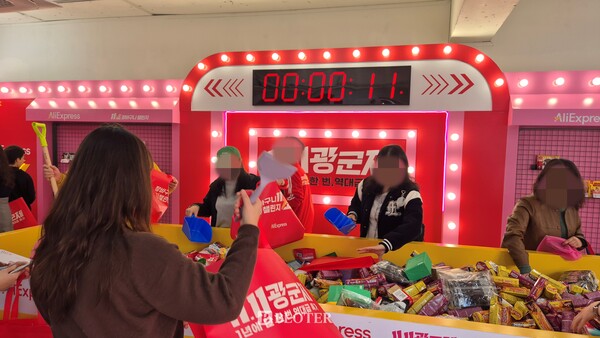 1층 체험존에서 방문객들이 제한시간 11초 안에 상품을 장바구니에 담는 게임에 참여하고 있다. /사진=이유리 기자